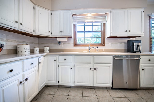 kitchen featuring dishwasher, sink, white cabinetry, light tile patterned flooring, and tasteful backsplash