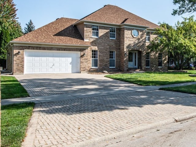 view of front of property with a front yard and a garage