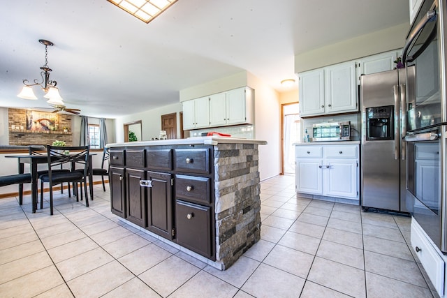 kitchen featuring decorative light fixtures, tasteful backsplash, white cabinetry, appliances with stainless steel finishes, and ceiling fan