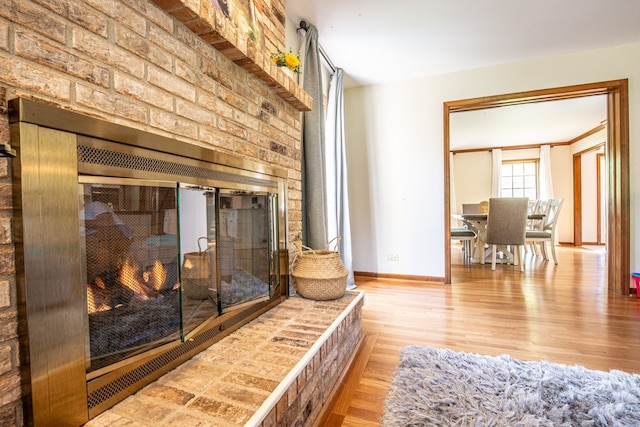 interior space featuring a brick fireplace and hardwood / wood-style flooring