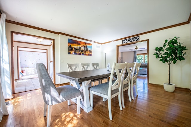 dining room with hardwood / wood-style floors, ceiling fan, and crown molding