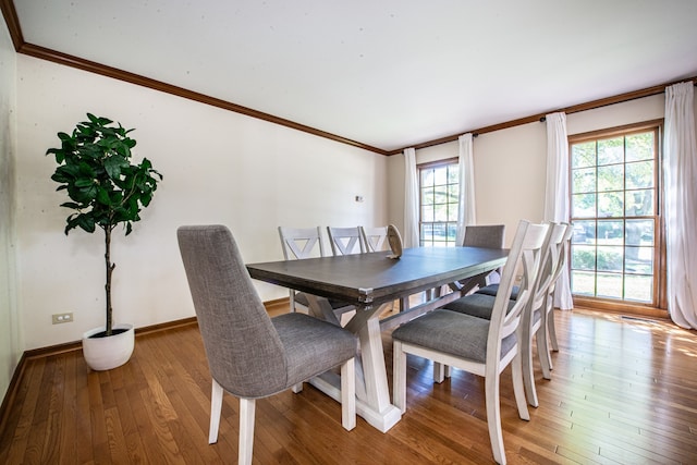 dining room with hardwood / wood-style flooring and crown molding