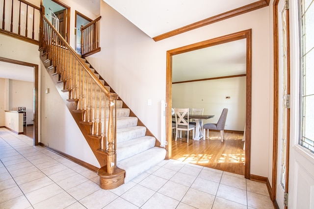 stairway featuring tile patterned floors and ornamental molding