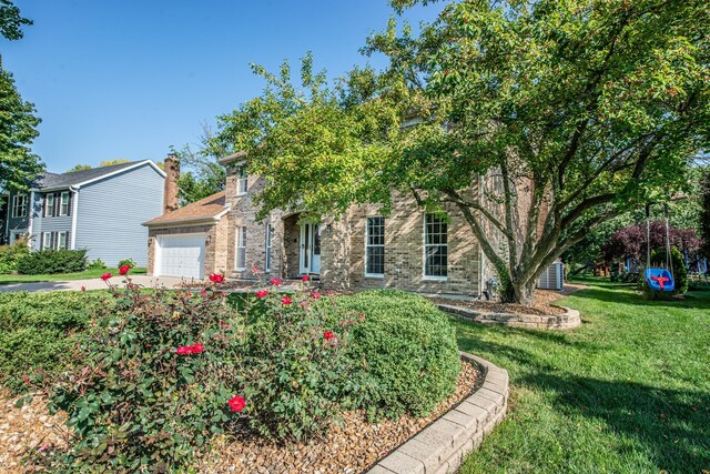 obstructed view of property featuring a front yard and a garage