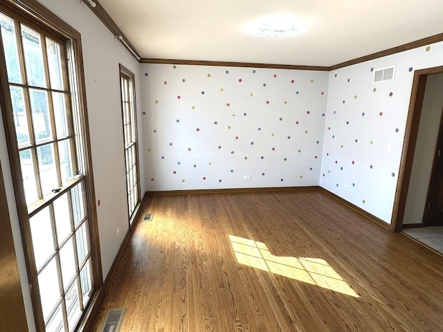 empty room with ornamental molding and hardwood / wood-style flooring