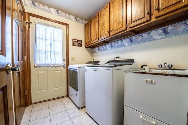 washroom with cabinets, light tile patterned flooring, and washing machine and clothes dryer