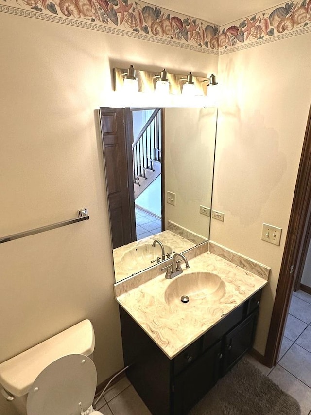 bathroom with toilet, tile patterned flooring, and vanity