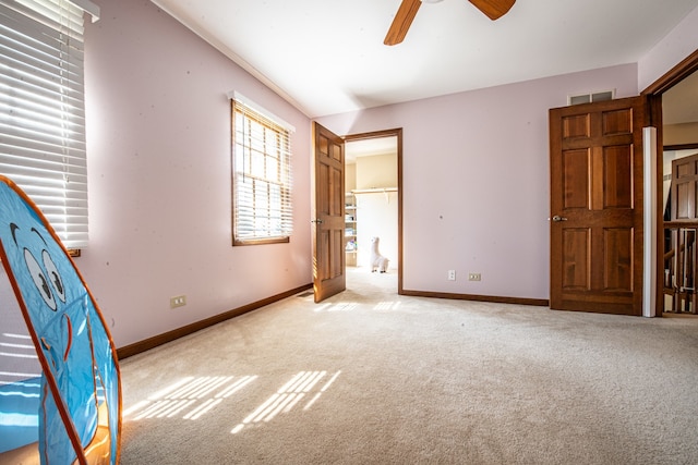 unfurnished bedroom with ceiling fan and light colored carpet