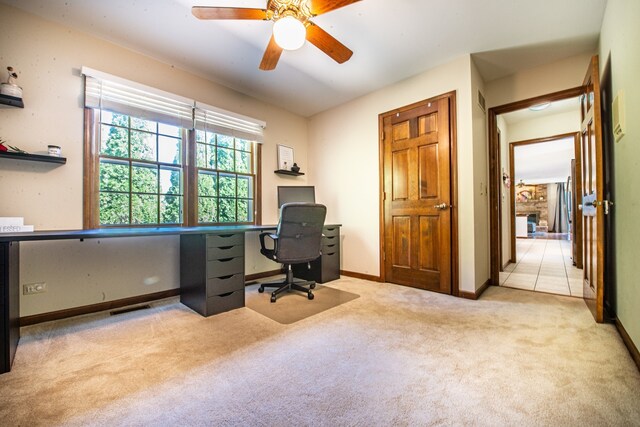 home office with ceiling fan, light carpet, and a fireplace