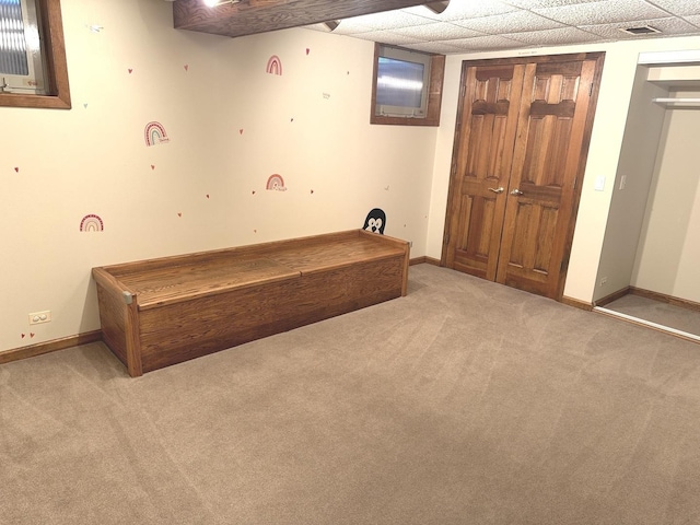 unfurnished bedroom with a paneled ceiling and light carpet