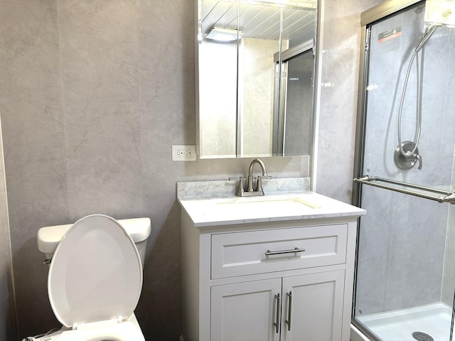 bathroom with an enclosed shower, vanity, and toilet