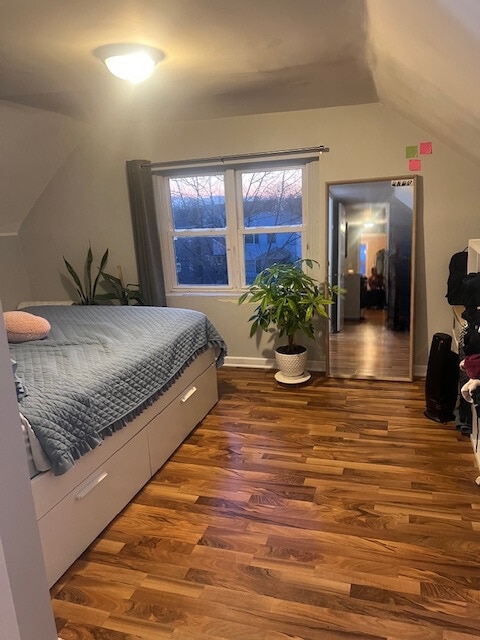 bedroom with lofted ceiling and dark hardwood / wood-style flooring