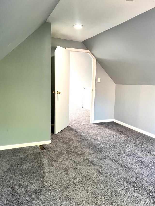 bonus room featuring vaulted ceiling and carpet flooring