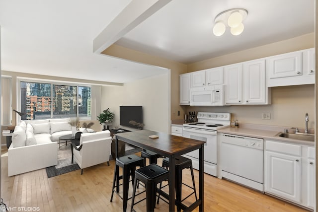 kitchen featuring white cabinetry, sink, white appliances, and light wood-type flooring