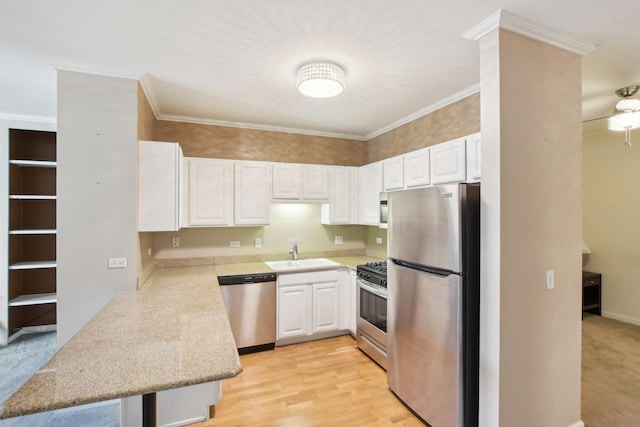 kitchen featuring white cabinets, stainless steel appliances, crown molding, and sink