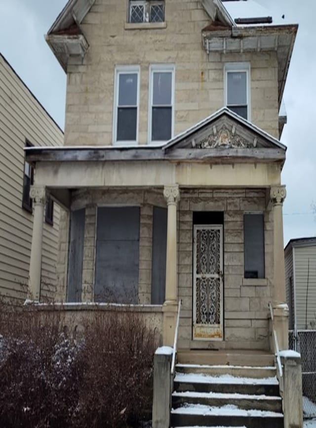 view of front of house with stone siding and fence