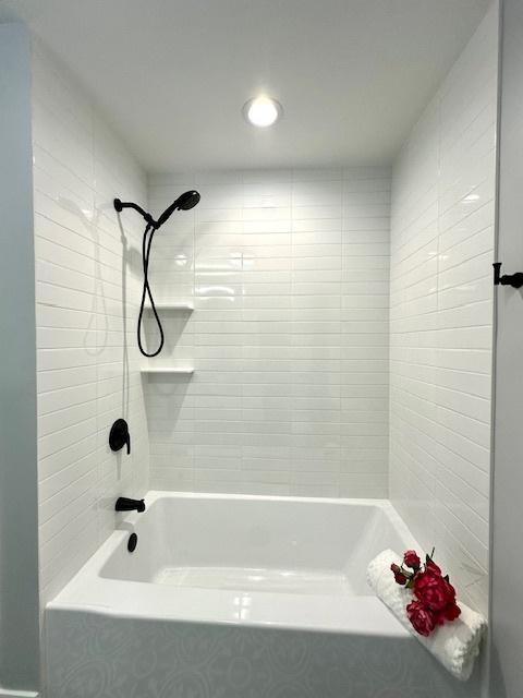 bathroom featuring tiled shower / bath