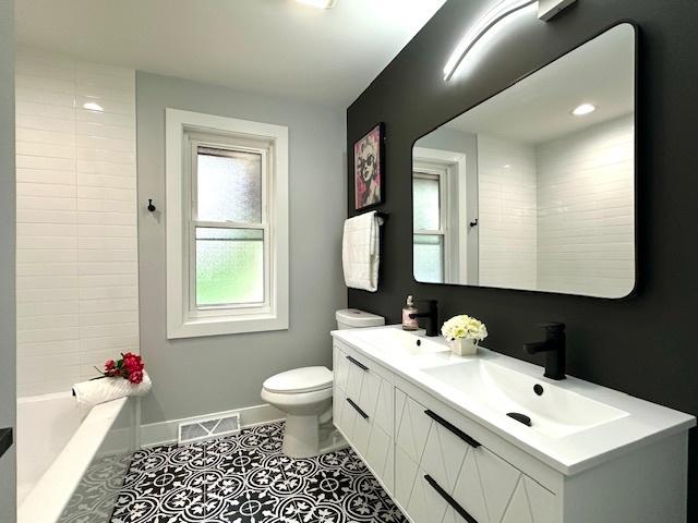 full bathroom featuring tile patterned flooring, vanity, bathtub / shower combination, and toilet