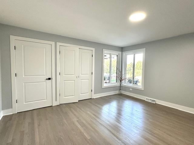 unfurnished bedroom with hardwood / wood-style flooring