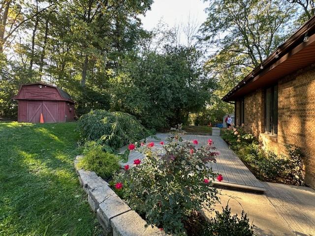 view of yard featuring a storage shed and a deck