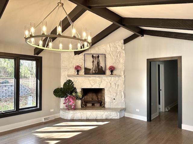 unfurnished living room featuring lofted ceiling with beams, dark hardwood / wood-style flooring, and a fireplace