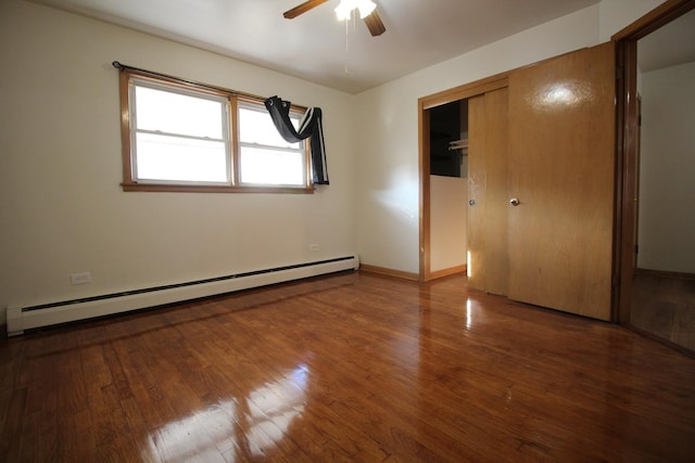 unfurnished bedroom featuring ceiling fan, baseboard heating, a closet, and hardwood / wood-style flooring