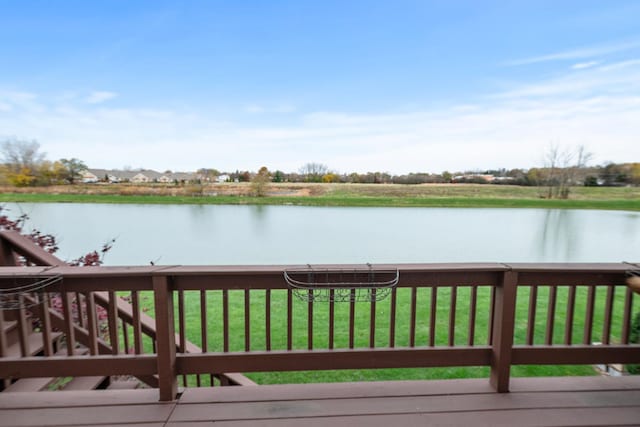 wooden deck featuring a lawn and a water view