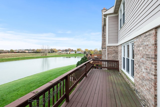 wooden deck featuring a lawn and a water view