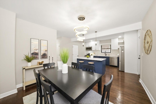 dining area featuring sink and dark hardwood / wood-style flooring