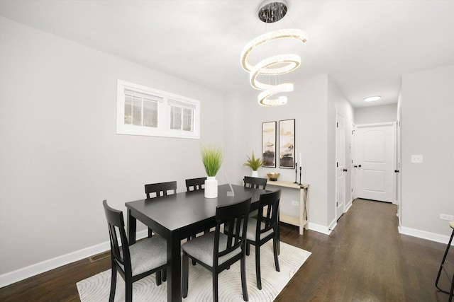 dining room with an inviting chandelier and dark hardwood / wood-style flooring