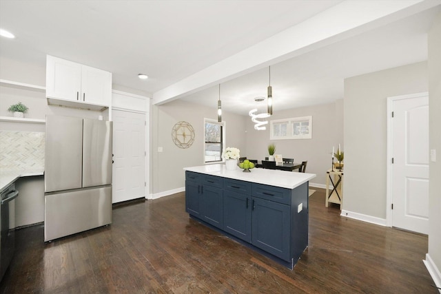 kitchen featuring decorative light fixtures, blue cabinetry, stainless steel refrigerator, white cabinets, and beamed ceiling