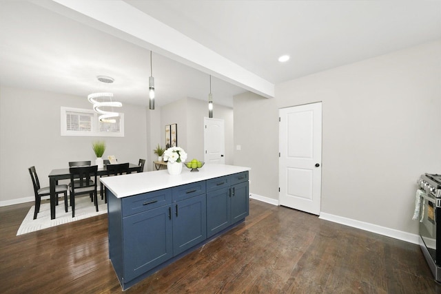 kitchen featuring a center island, stainless steel gas range oven, blue cabinetry, dark hardwood / wood-style flooring, and pendant lighting