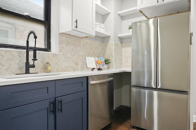 kitchen with stainless steel appliances, white cabinetry, decorative backsplash, and sink