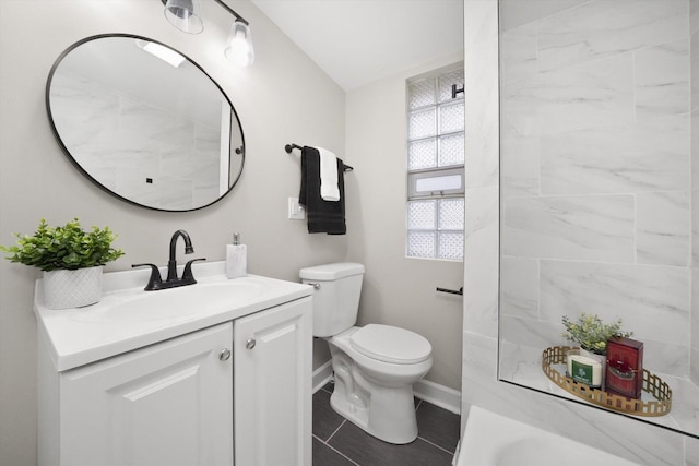 bathroom featuring toilet, a bath, and vanity