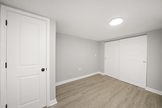 unfurnished bedroom with a closet and light hardwood / wood-style flooring