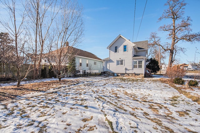 view of snow covered back of property