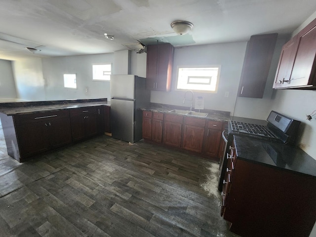 kitchen with sink, stainless steel appliances, dark hardwood / wood-style flooring, and kitchen peninsula