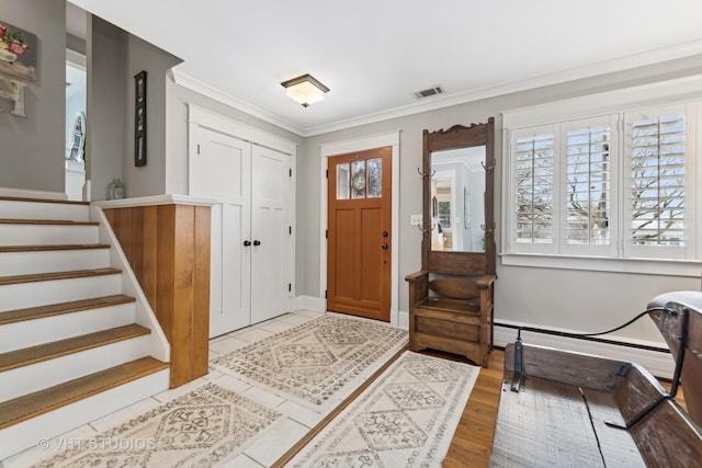 tiled foyer entrance featuring crown molding and baseboard heating