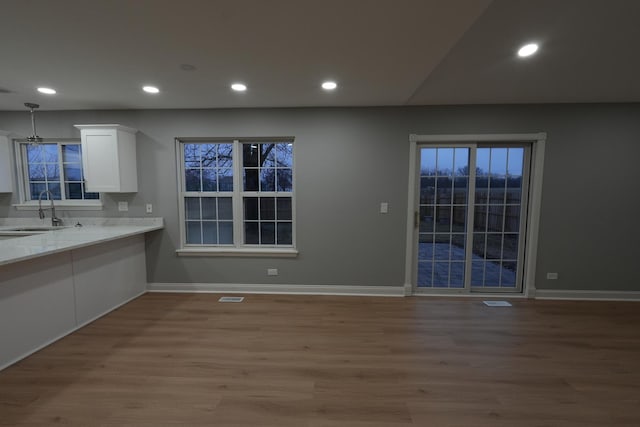 kitchen with sink, white cabinets, and hardwood / wood-style floors