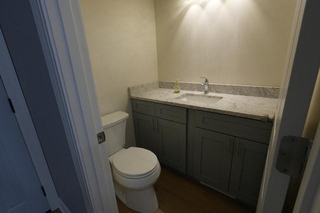 bathroom with hardwood / wood-style floors, vanity, and toilet