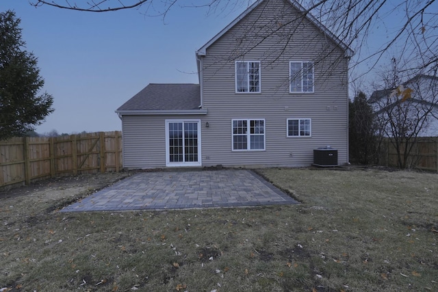 rear view of property with a patio area, central AC unit, and a yard