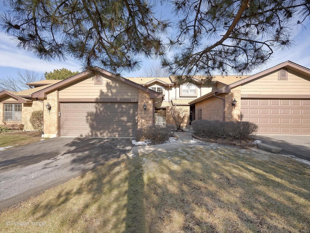 ranch-style house with a front yard and a garage