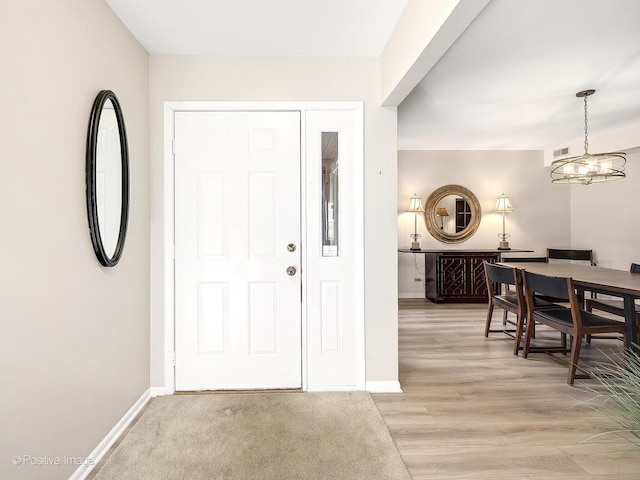 foyer featuring a chandelier and light hardwood / wood-style flooring