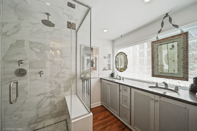 bathroom featuring wood-type flooring, a shower with shower door, and vanity