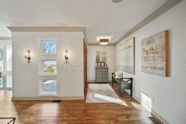 doorway with ornamental molding, plenty of natural light, and wood-type flooring