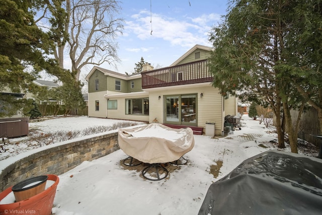 snow covered property with a balcony