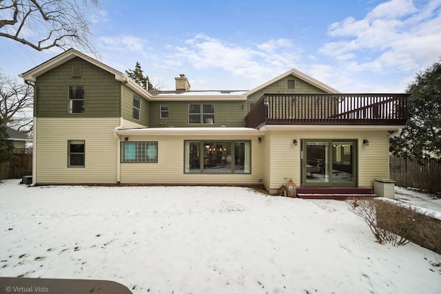 snow covered house featuring a balcony