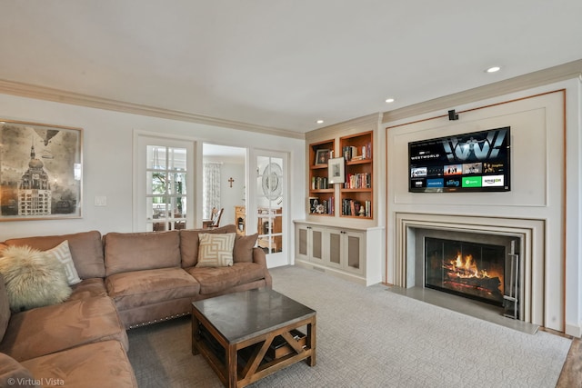 carpeted living room featuring ornamental molding and built in shelves