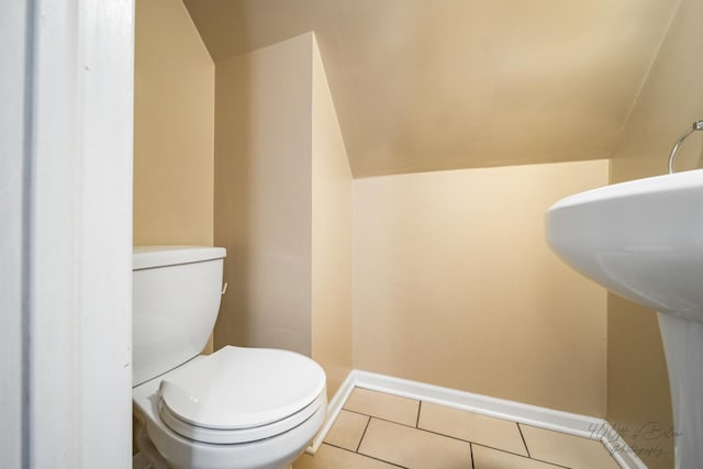 bathroom featuring sink, tile patterned floors, toilet, and vaulted ceiling