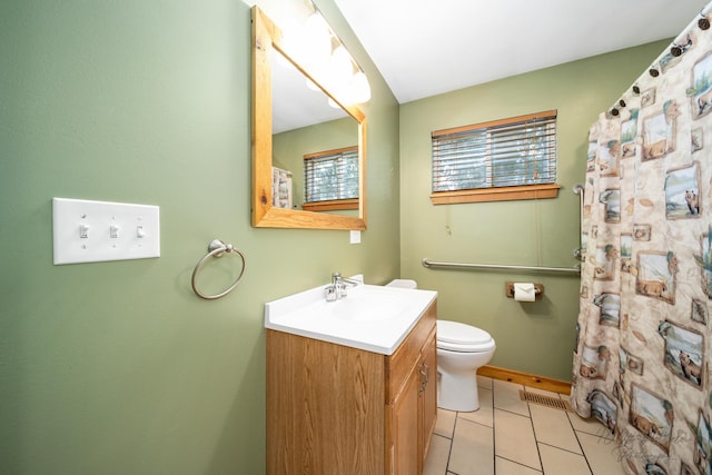 bathroom featuring toilet, tile patterned flooring, walk in shower, and vanity